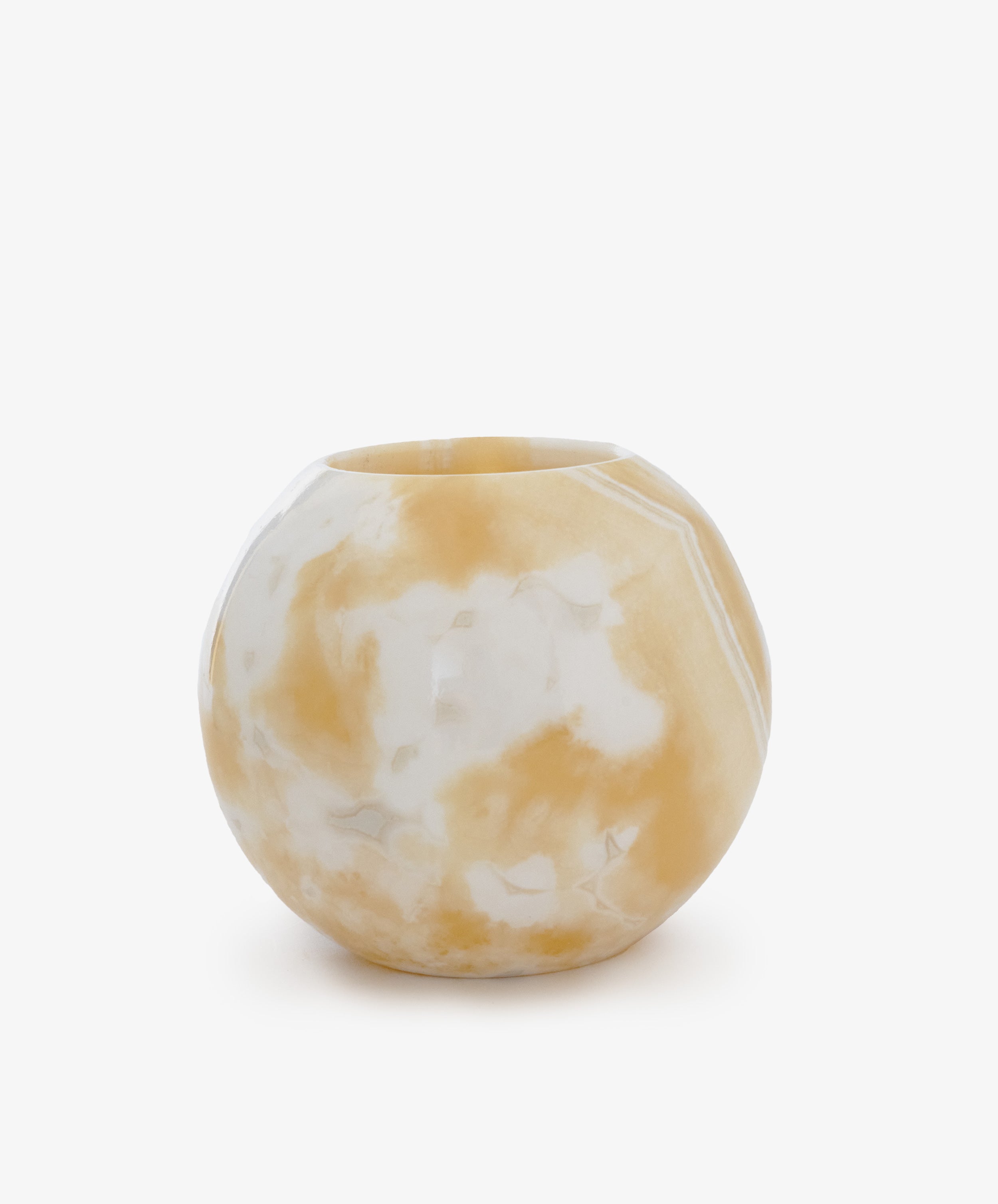 The Akila Candleholder features a round, faceted design with a beige and white marbled pattern, reminiscent of Egyptian Alabaster, displayed against a plain white background.