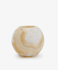 The Akila Candleholder features beige and white marble swirls, evoking the look of Egyptian alabaster, and is displayed on a plain white background.