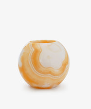 The Akila Candleholder is a round orange and white marble vase with a smooth, polished surface, uniquely crafted and displayed against a plain white background.