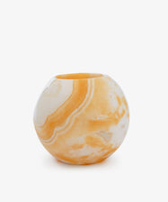 The Akila Candleholder is a round orange and white onyx vase with a small opening, reminiscent of an Egyptian Alabaster candle holder, shown against a plain white background.