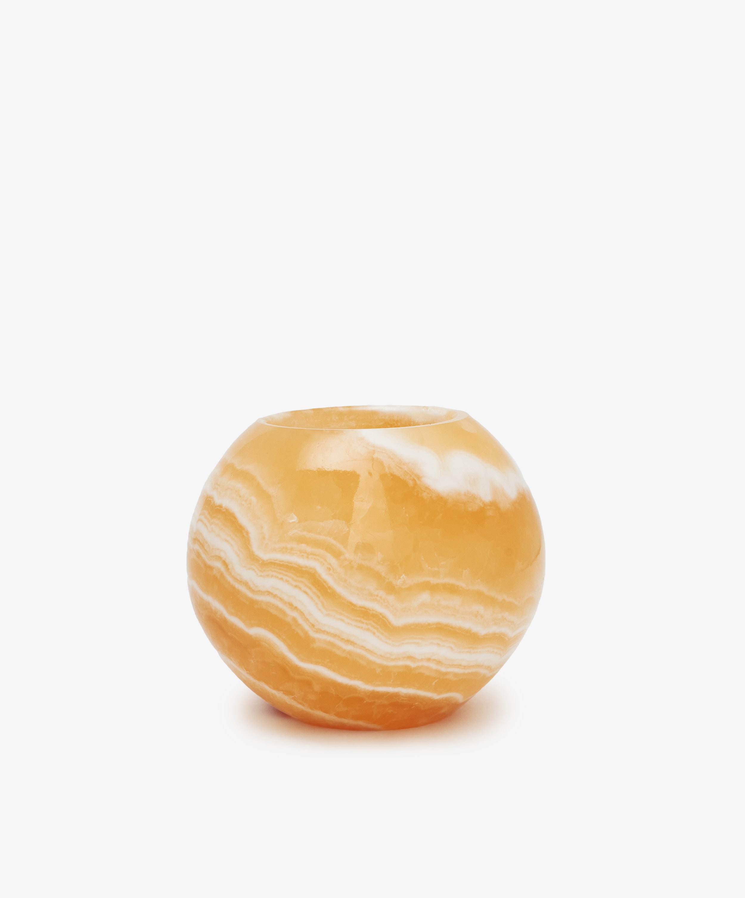 The Akila Candleholder is handcrafted from round, orange onyx with white and light orange natural striations, reminiscent of Egyptian Alabaster from Luxor, shown against a plain white background.