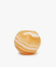 The Akila Candleholder is handcrafted from round, orange onyx with white and light orange natural striations, reminiscent of Egyptian Alabaster from Luxor, shown against a plain white background.