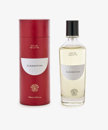 A clear glass bottle of Clementina Eau de Toilette sits beside a matching red cylindrical box, suggesting notes of bergamot and orange flower.