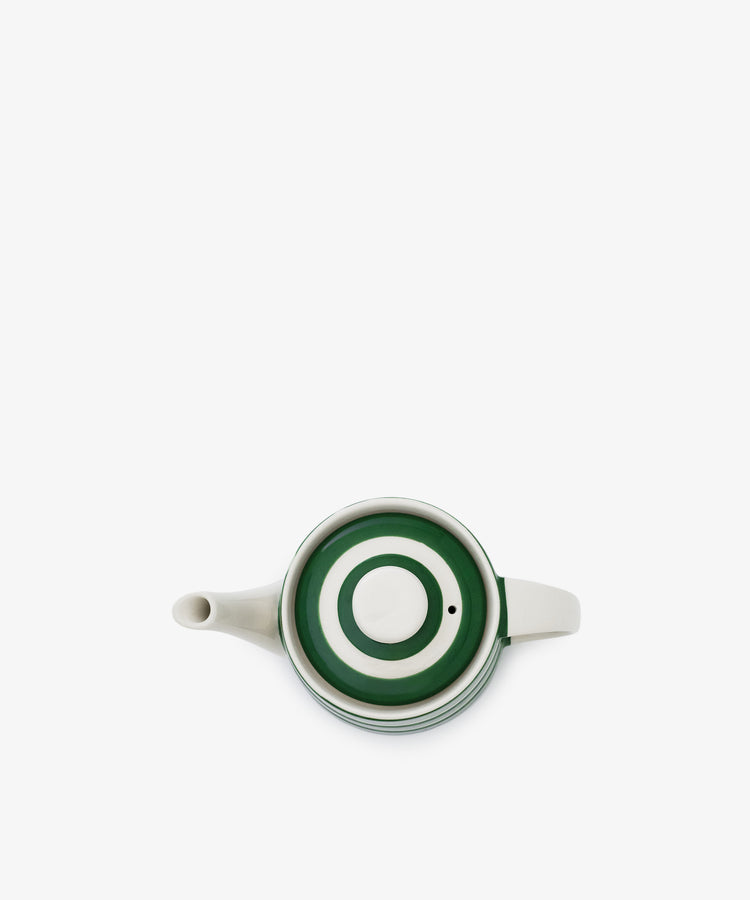 The Classic Teapot, a white kitchen essential, displays a green and white concentric circle pattern on its lid, seen from above against a plain white background.