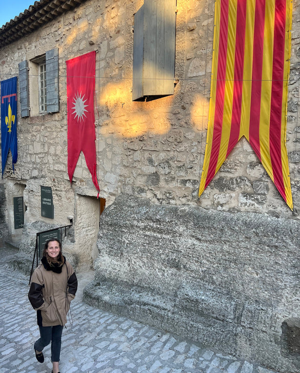 Cobblestone street lined with stone buildings and a women walking