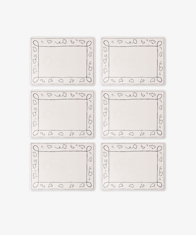 The Capriccio Placemat Set of 6 features rectangular white wipeable mats with simple fruit and leaf line borders, arranged in two rows of three—a stylish PORTA home accent.