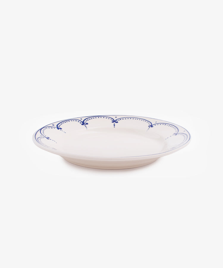 Side view of Arco dinner plate in white glazed ceramic with dark blue painted border design.