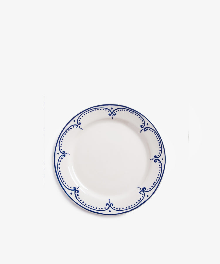 Arco small plate. Overhead view of white glazed ceramic plate with dark blue handpainted border design.