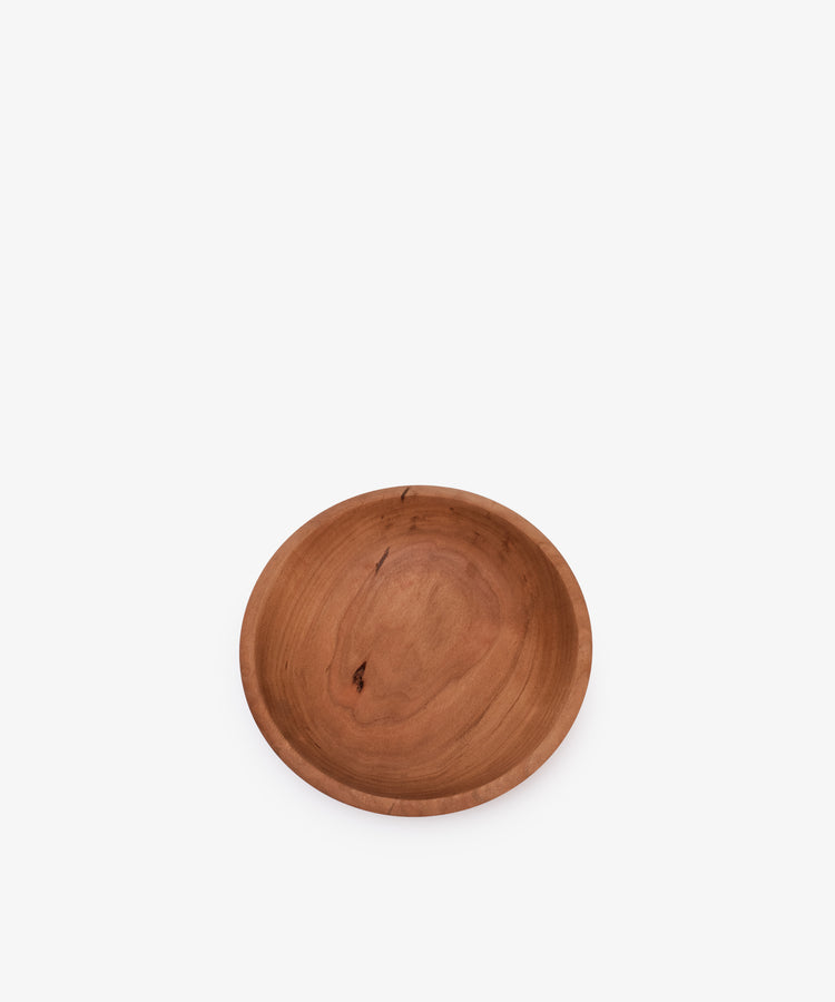 The August Wood Serving Bowl is a round, shallow bowl made from American dark cherry wood with a natural grain pattern, featured on a plain white background.