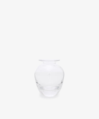 The Gem Bud Vase is a clear glass vase with a wide, round body and short, narrow neck, inspired by hand-blown bud vases from the South of France. It is showcased against a plain white background.