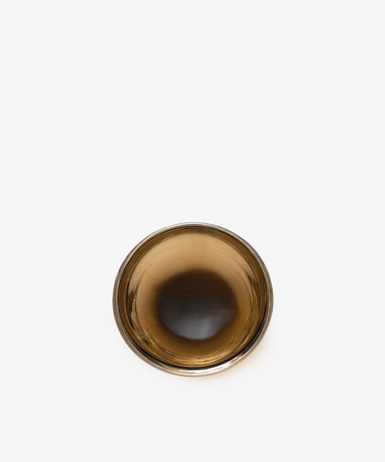Overhead view of an empty Gem Dish, made of brown glass, on a plain white background.