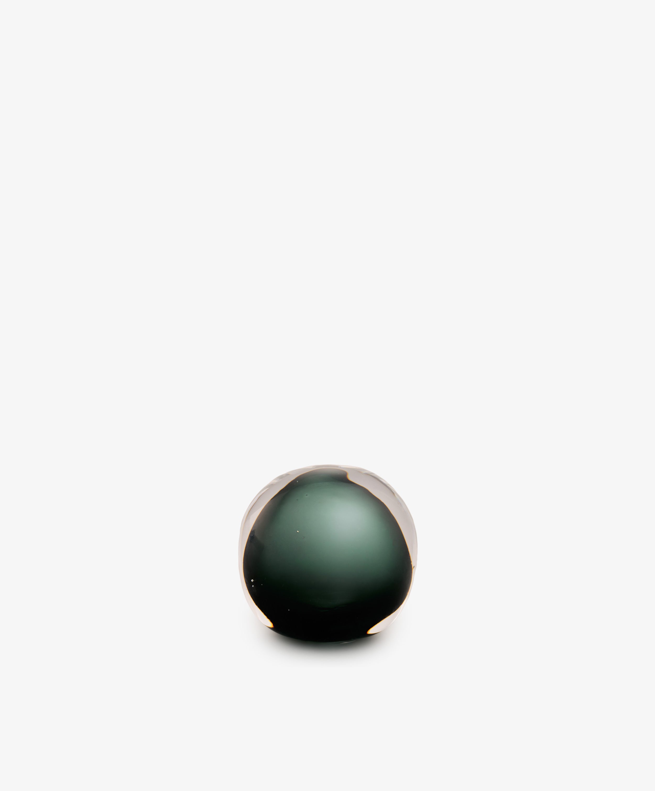 A Pallino Paperweight, hand-blown from glass in a spherical shape with a dark green core.