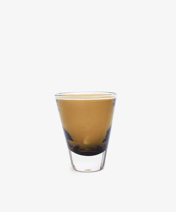 A set of two Gem Glasses, each with a clear conical shape, showcases light brown coffee against a plain white backdrop—an elegant choice for those who value luxury glassware.