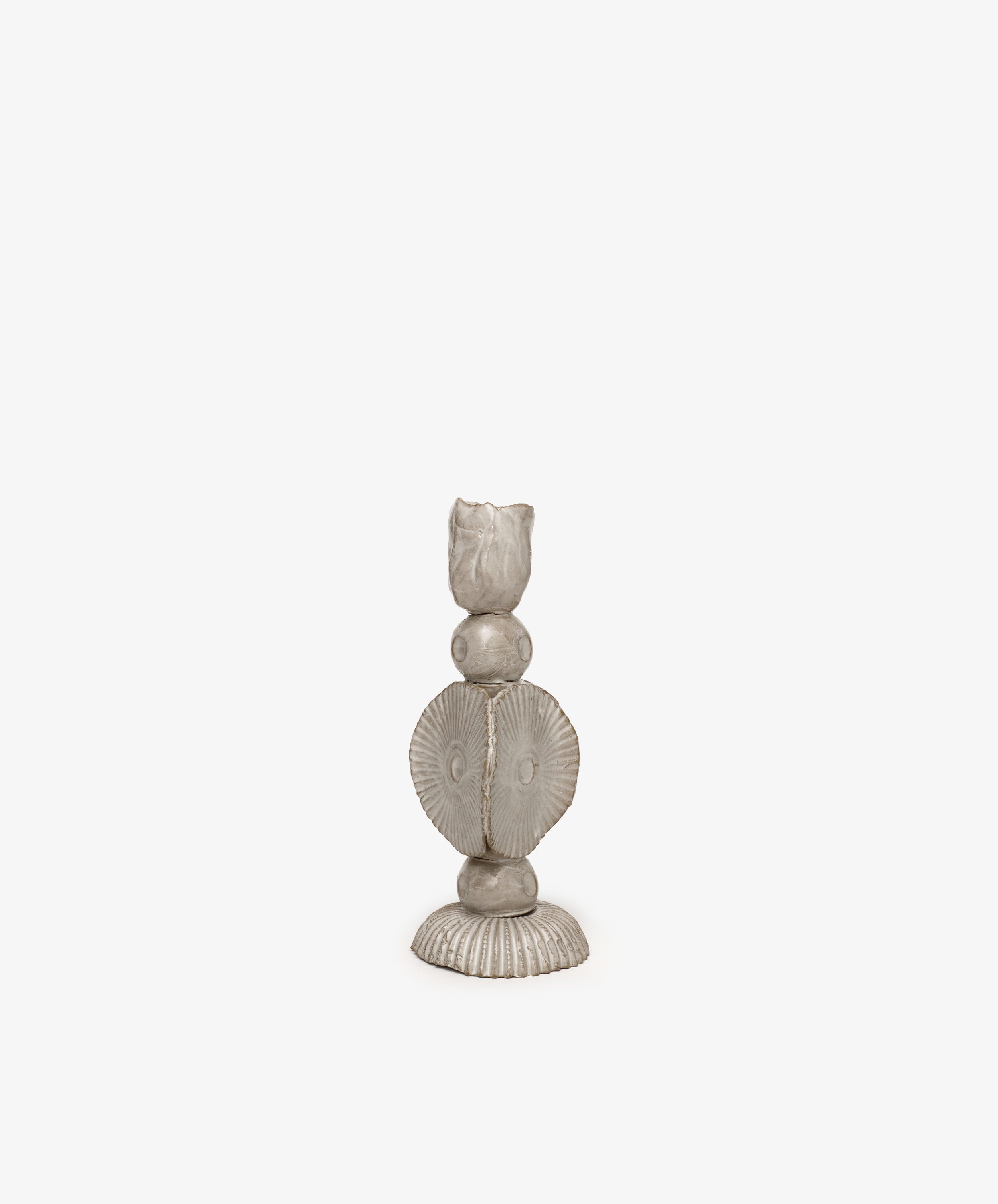 The Circulo Candleholder is a hand-moulded ceramic piece featuring a textured base, round elements, and a fluted, shell-like middle, creating a striking sculptural form against a plain white background.