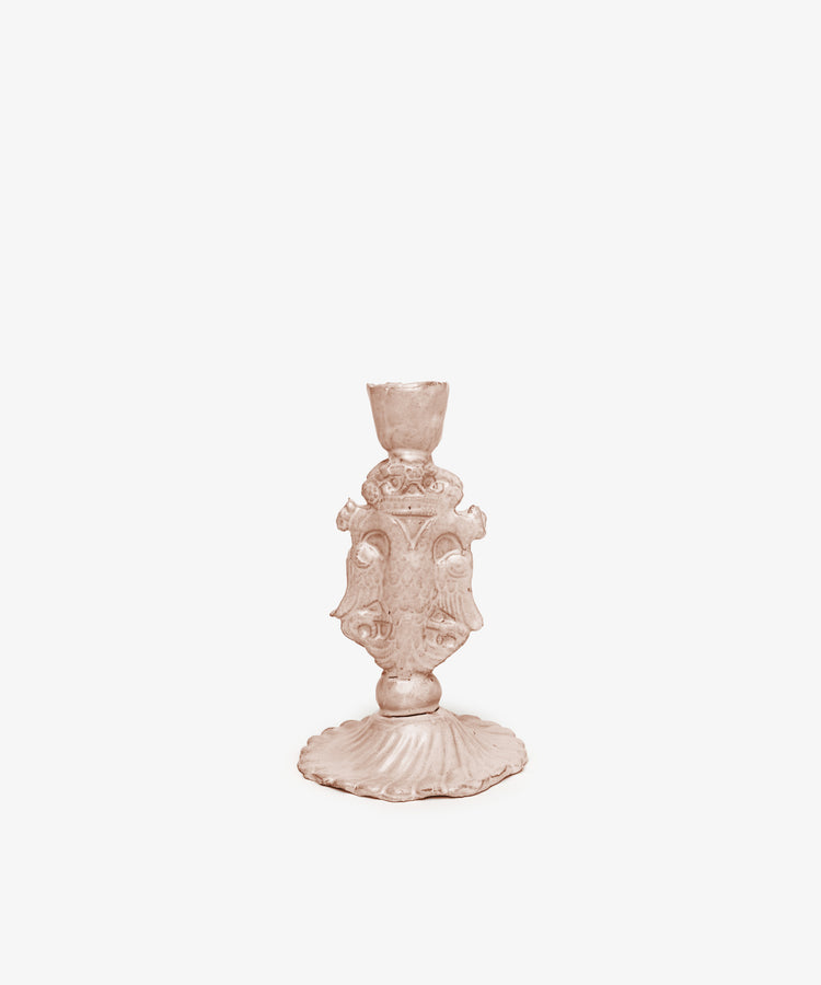 The Aguila Bicefala Candleholder is a bronze-toned ornate metal piece with decorative detailing and a fluted base, featuring a sculptural form and displayed on a plain white background.