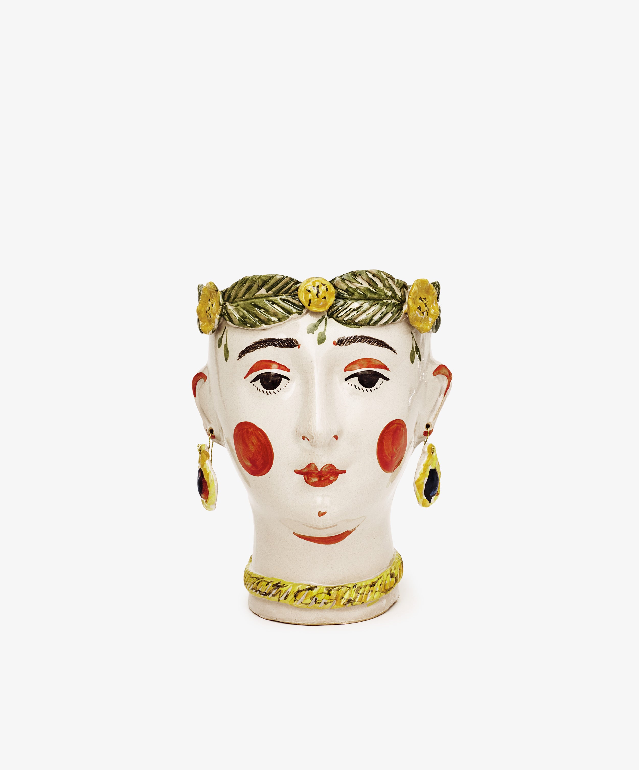 Testa di Moro, Alfonsina: A ceramic vase shaped like a womans head with red cheeks, gold earrings, a necklace, and a green leaf crown with yellow flowers. Sculptural and unique homeware. Displayed on a plain white background.