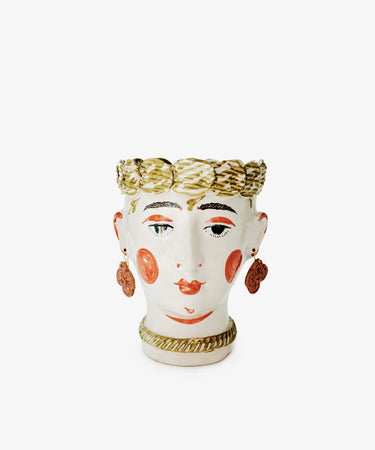 Cabeza Recipiente, Biloba by The Exvotos is a handmade ceramic vase shaped and painted like a human face, featuring gold hair, red cheeks, earrings, and a decorative collar—an exquisite sculptural decor piece.