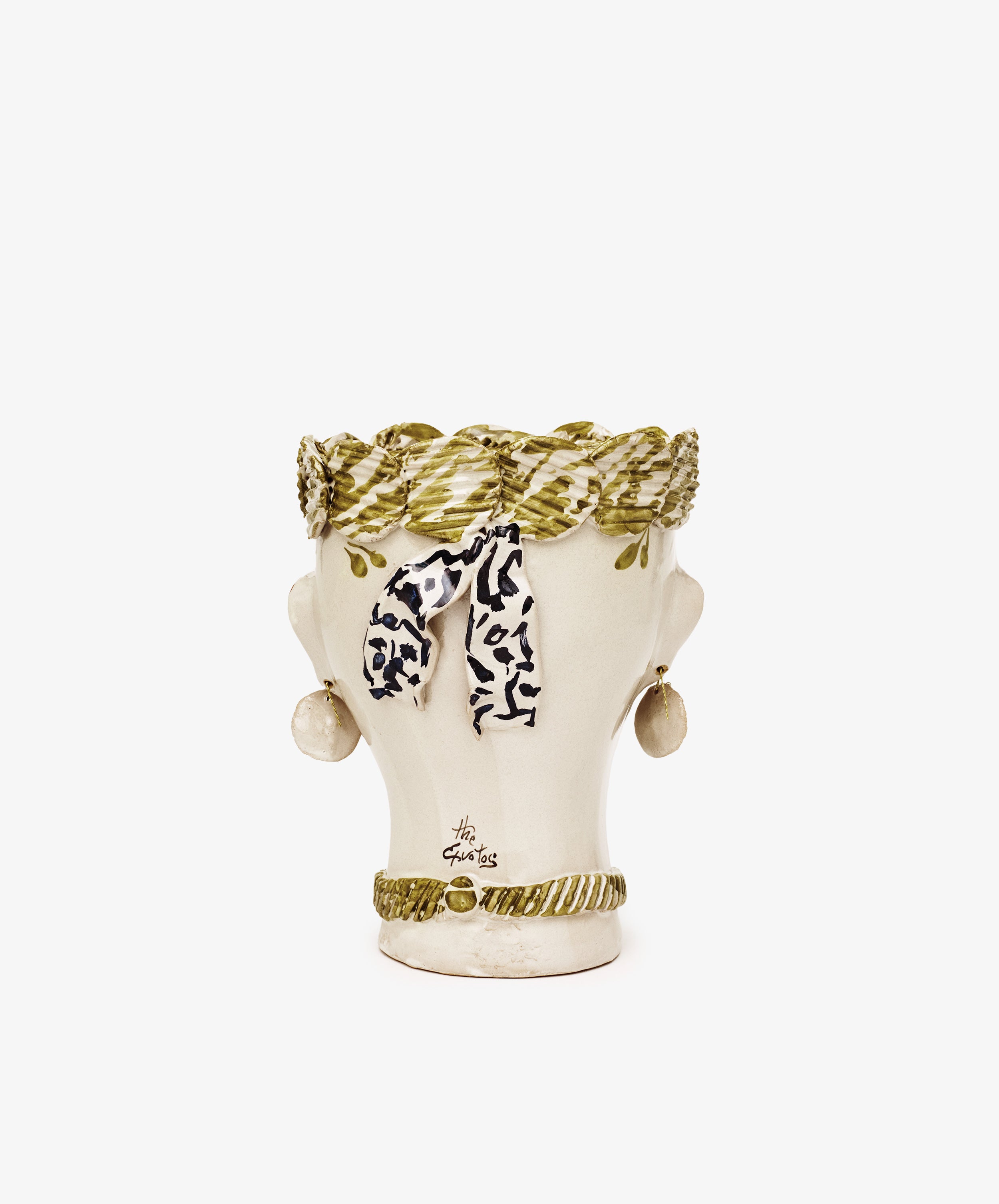 The Testa di Moro, Biloba is a ceramic head vase featuring a sculptural green braided headdress, black and white scarf, earrings, and green necklace set against a plain white background—a striking homeware piece.