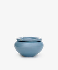 The Mix & Match Ashtray is a round, blue, hand-glazed ceramic ashtray with a wide rim and one groove for holding a cigarette, evoking vintage style and displayed on a plain white background.