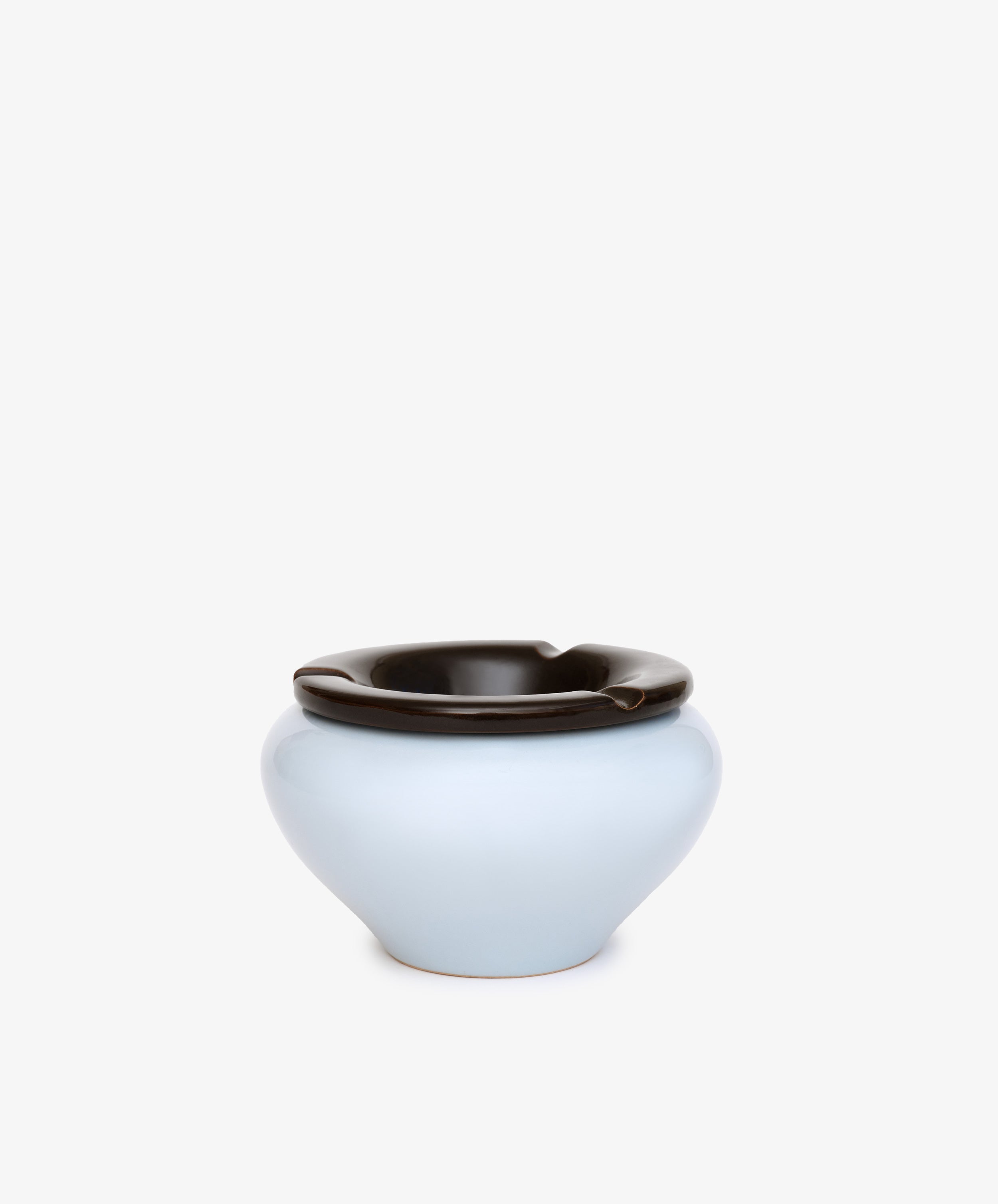 Handmade in Italy, the Mix & Match Ashtray is a light blue chunky ceramic piece with a glossy dark brown interchangeable lid featuring notches, shown on a plain white background.