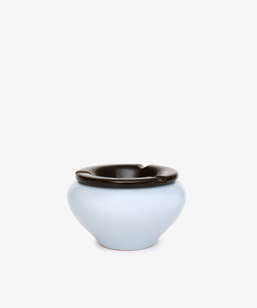 Handmade in Italy, the Mix & Match Ashtray is a light blue chunky ceramic piece with a glossy dark brown interchangeable lid featuring notches, shown on a plain white background.
