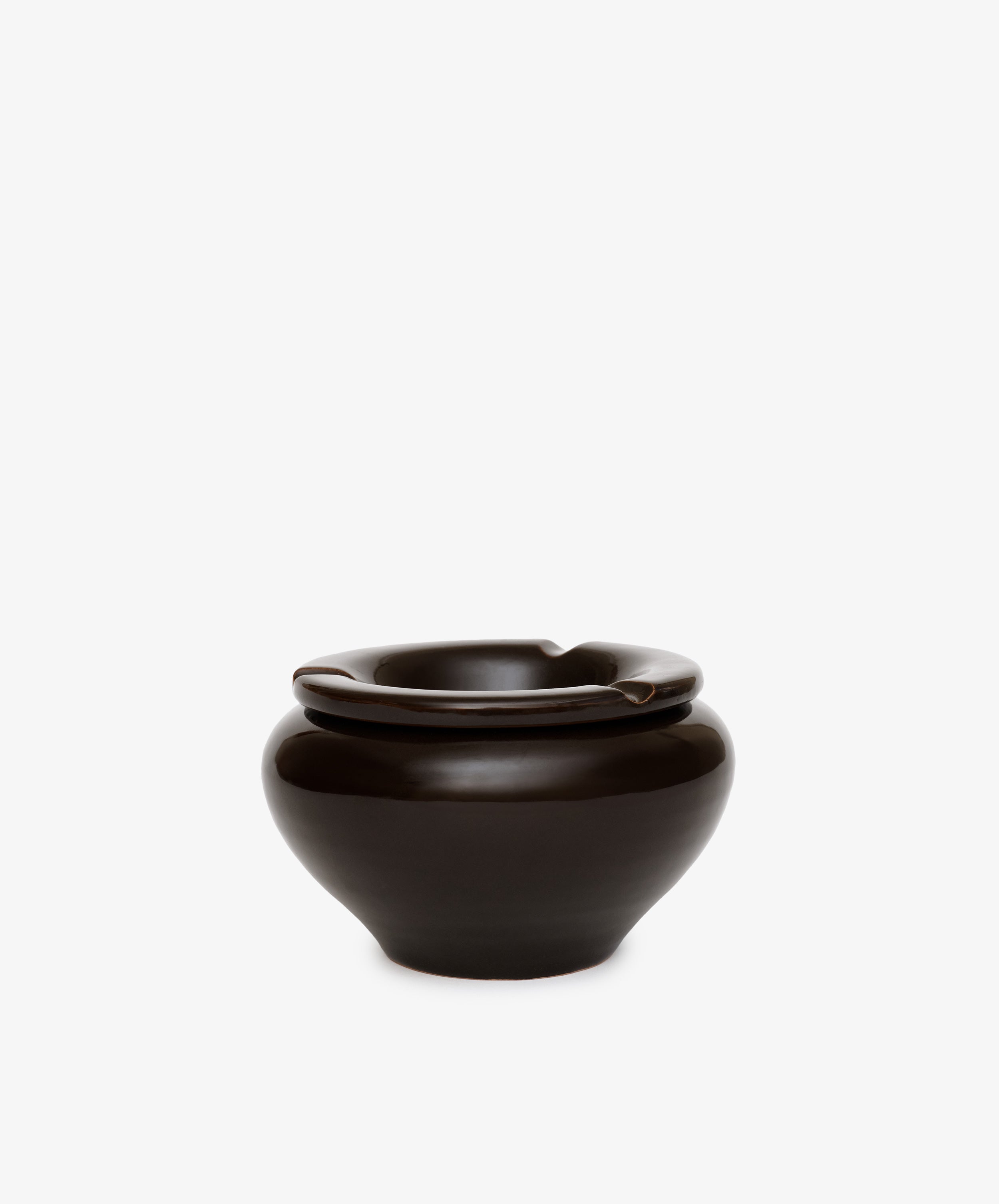 The Mix & Match Ashtray is a glossy dark brown ceramic piece with a chunky, wide rounded base and three rim notches, handmade in Italy and shown against a plain white background.