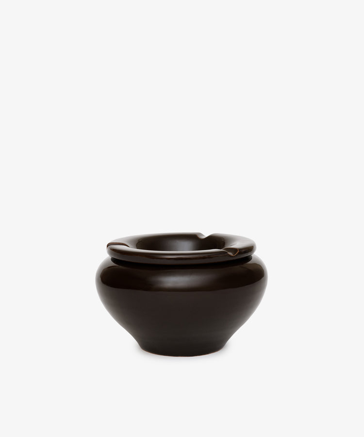 The Mix & Match Ashtray is a glossy dark brown ceramic piece with a chunky, wide rounded base and three rim notches, handmade in Italy and shown against a plain white background.