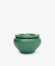 The Mix & Match Ashtray is a glossy green, hand-glazed ceramic pot with a wide rounded body and thick folded rim, exuding vintage charm against a plain white background.