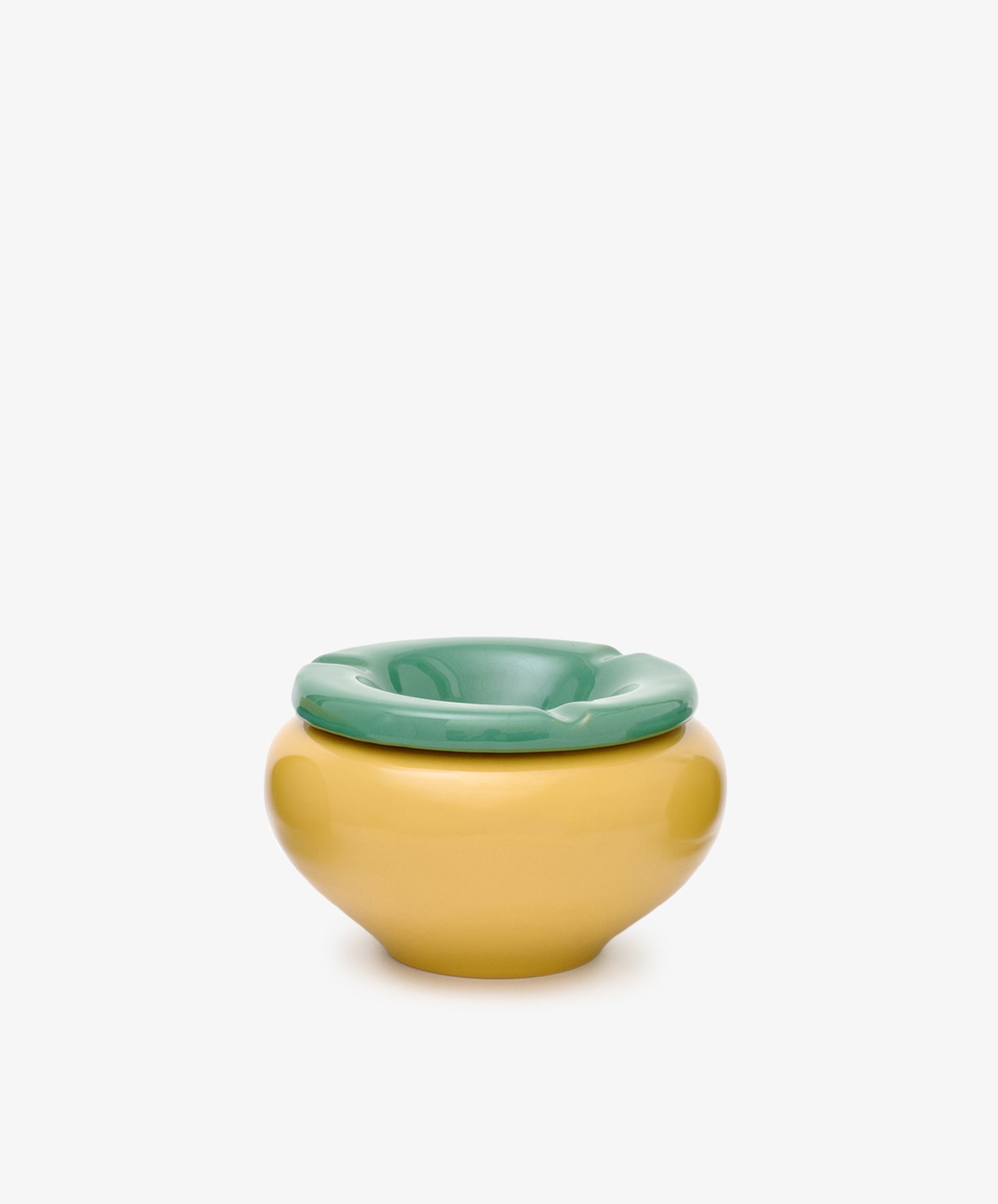 The Mix & Match Ashtray, featuring playful yellow and green hues in chunky ceramic, sits against a plain white background—its design evoking the whimsical forms of childhood objects, handmade in Italy.
