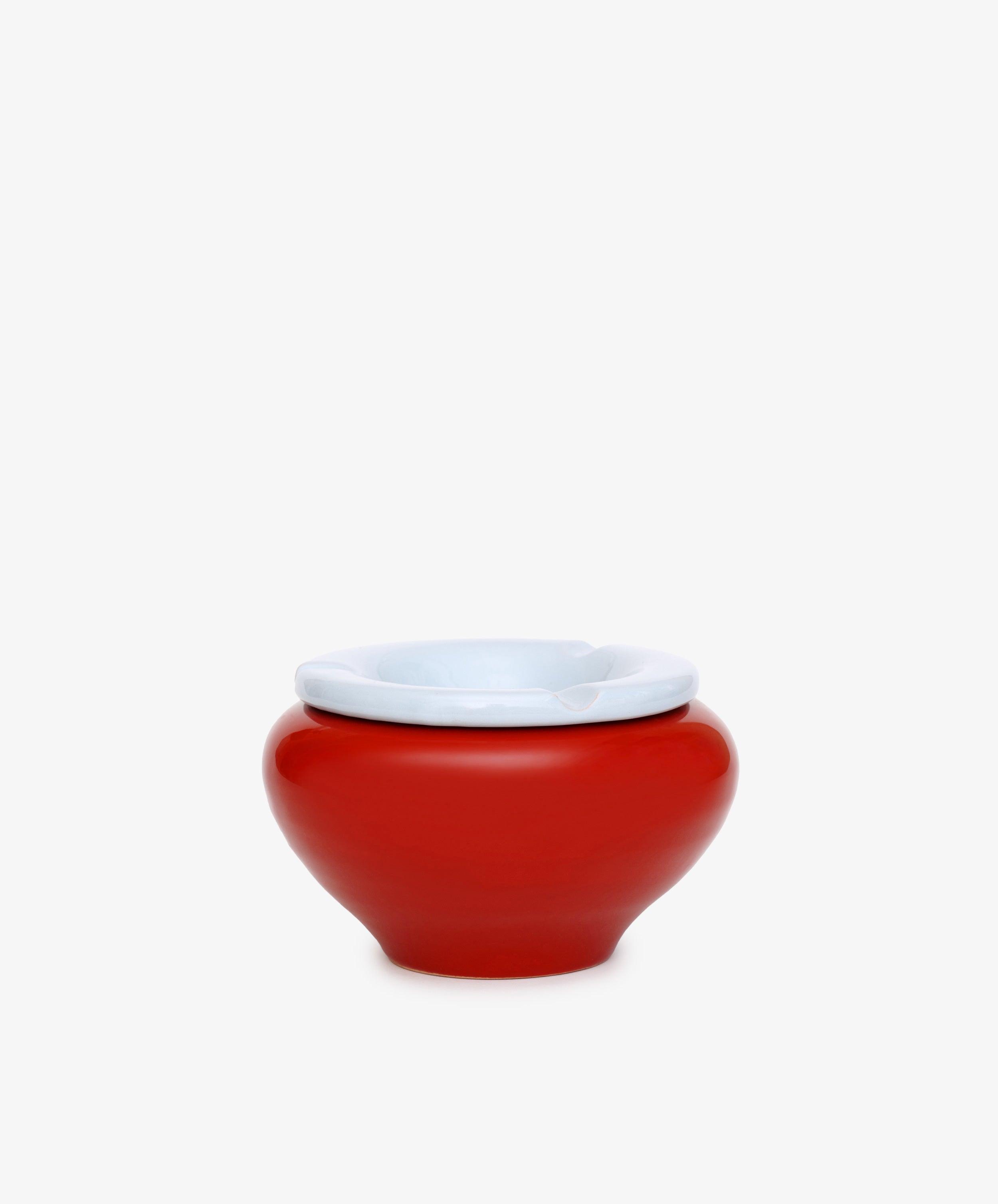 The Mix & Match Ashtray is a chunky, handmade ceramic piece from Italy, featuring a red, round shape with a white rim and displayed on a plain white background.