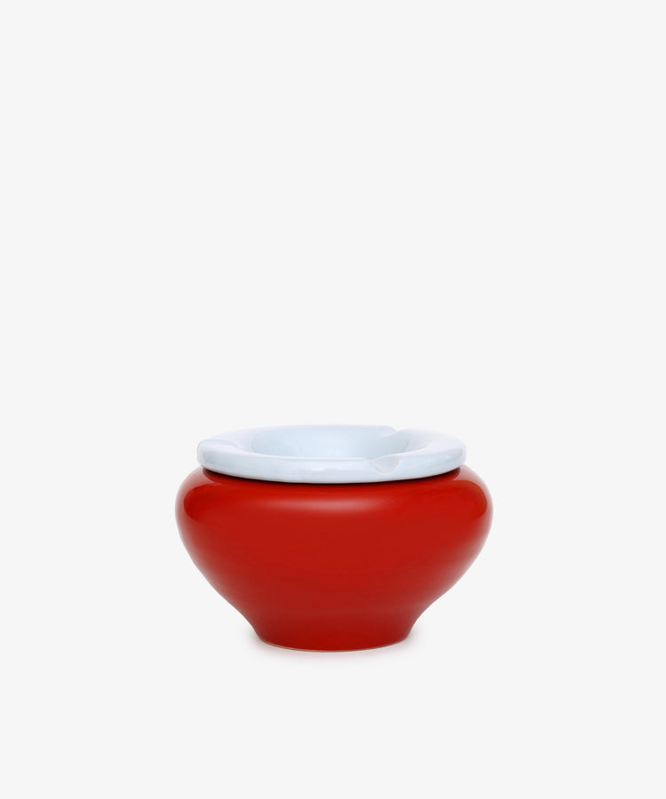 The Mix & Match Ashtray is a chunky, handmade ceramic piece from Italy, featuring a red, round shape with a white rim and displayed on a plain white background.