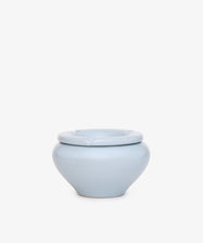 The Mix & Match Ashtray is a chunky ceramic piece, handmade in Italy with a light blue round body and notched rim, shown on a plain white background.
