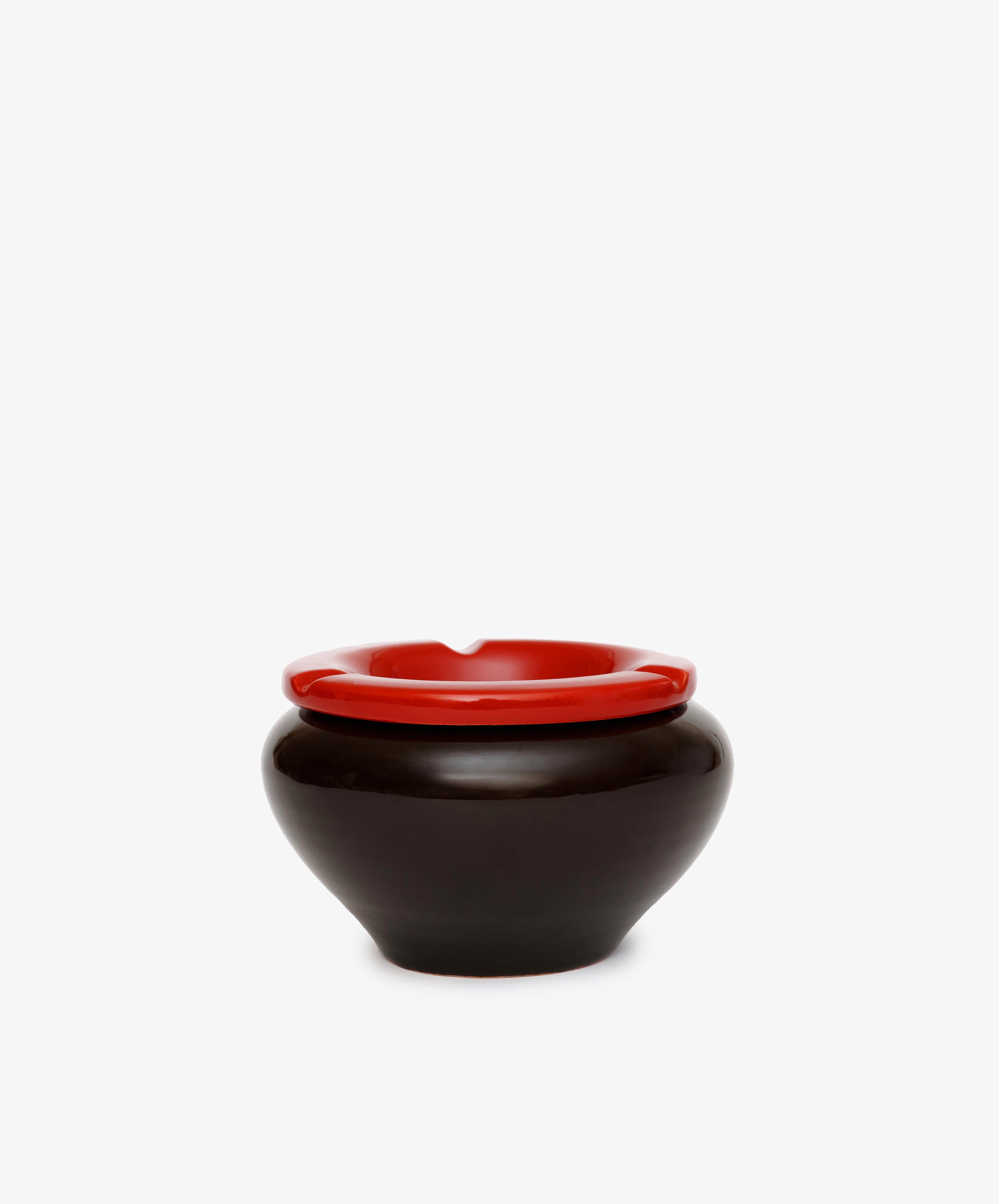 The Mix & Match Ashtray, a round black ceramic piece with a bold red rim, is displayed against a plain white background.