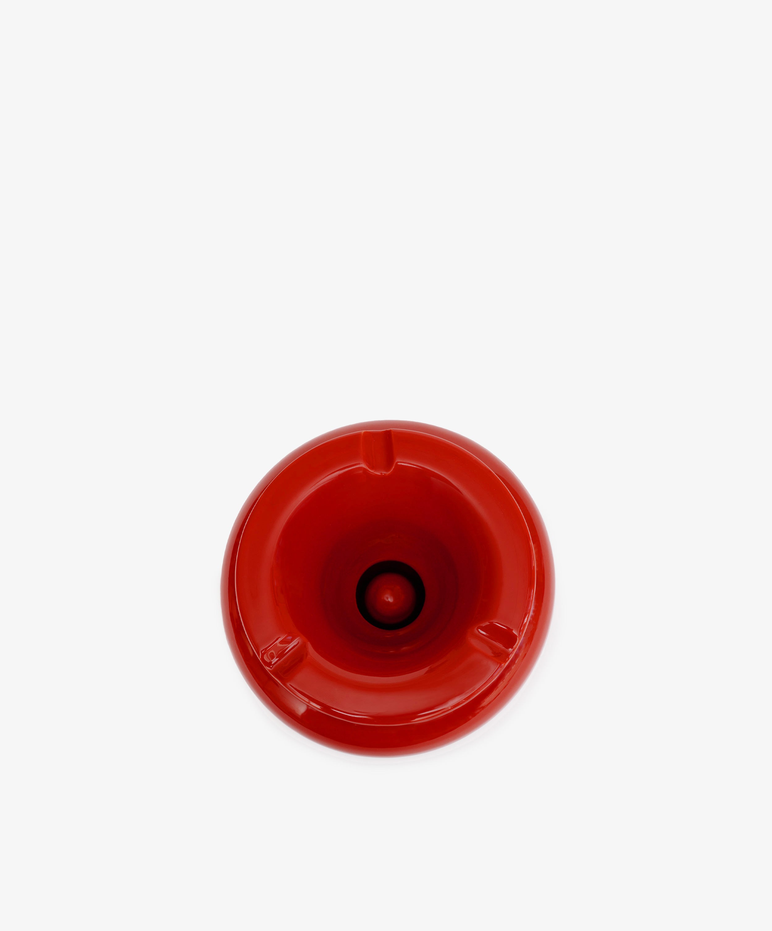 The Mix & Match Ashtray is a chunky, handmade ceramic piece from Italy, featuring a red circular design with three notches, shown from above on a plain white background.