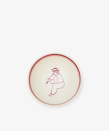The Folk Cereal Bowl, Farmer features a hand-painted red rim and a simple red line drawing of a seated person holding flowers at the center—perfect for mix and match tableware collections.