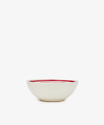 The Folk Cereal Bowl, Farmer features a white ceramic exterior and red interior, crafted by an Italian ceramist and shown against a plain white background.