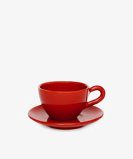 The Guido Coffee Set features a plain red breakfast cup and saucer on a matching red plate, set against a white background and evoking the ambiance of an Italian café.