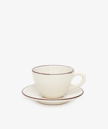The Guido Coffee Set features a cream-colored ceramic breakfast cup with handle and a matching saucer, both accented by a thin brown rim, displayed against a plain white background.