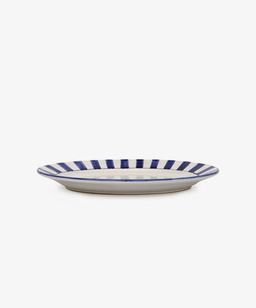 The Julius Oval Serving Platter features a white ceramic base with bold, hand-painted blue vertical stripes along the rim, displayed against a plain white background.