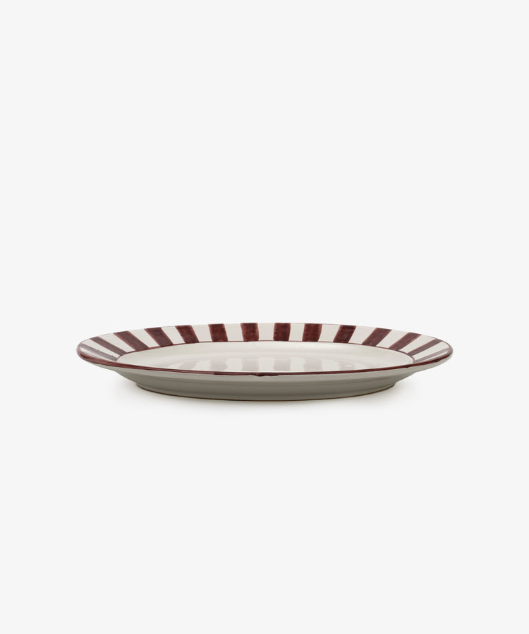 The Julius Oval Serving Platter features a white center with bold, hand-painted maroon stripes around the rim, displayed against a white background.