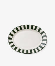 The Julius Oval Serving Platter features a white ceramic center accented by bold hand-painted stripes in alternating dark green and white along the border.