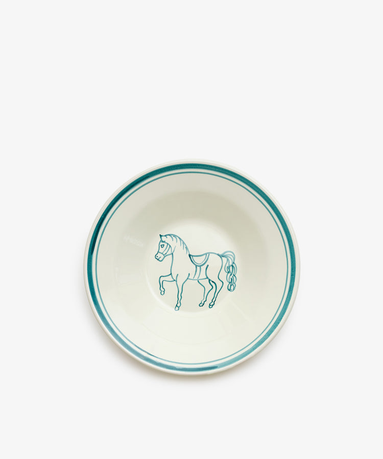 The Folk Pasta Bowl, Horse features a white ceramic design with teal rim accents and a hand-painted horse at the center, crafted by an Italian ceramist.