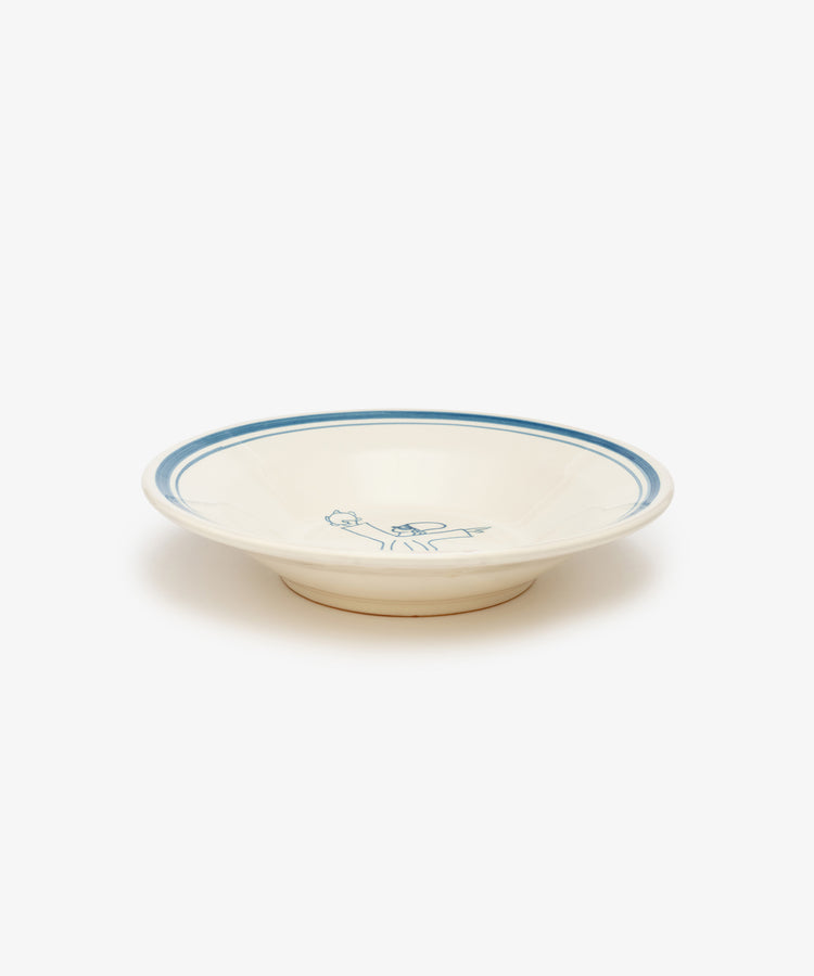 The Folk Pasta Bowl, Jester is a cream-colored ceramic bowl with a blue rim and a blue floral center design, hand-glazed by an Italian ceramist and photographed on a white background—a timeless tableware piece.