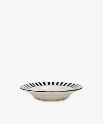 The Julius Serving Platter is a shallow, round ceramic plate with a white base and bold black vertical stripes around the rim, set against a plain white background.
