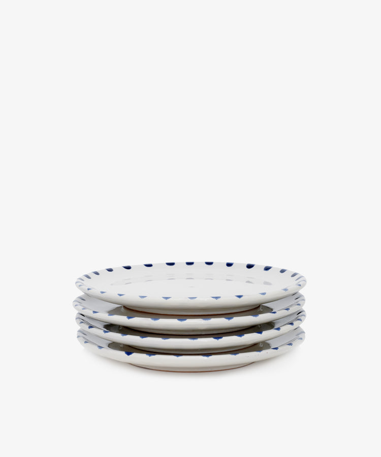 Stack of four white ceramic plates with blue accents.