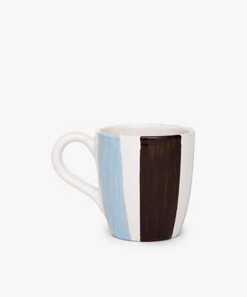 The Mina Mug is a unique ceramic piece with hand-painted vertical blue and brown stripes on white and a curved handle—an elegant addition to any collection.
