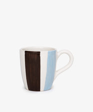 The Mina Mug is a unique ceramic mug with a white base, decorated with vertical hand-painted brown and blue stripes, set against a plain white background.