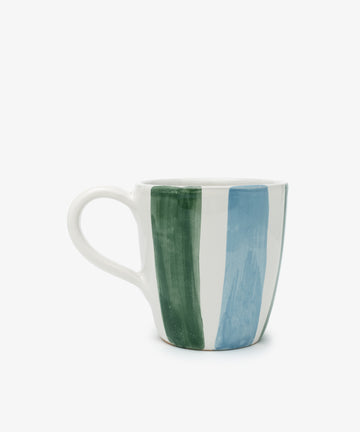 The Mina Mug is a white ceramic mug featuring vertical green and blue hand-painted stripes, displayed against a plain white background.