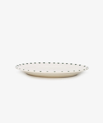 The Nina Oval Serving Platter is a white, hand-glazed ceramic plate featuring a thin dark dotted rim—an elegant entertaining essential, ideal for serving platters.