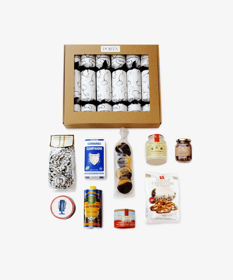 The Holiday Pantry is a gourmet food hamper gift box with nine individually wrapped Italian items—pasta, olive oil, jams, and sauces—all arranged neatly on a white background.